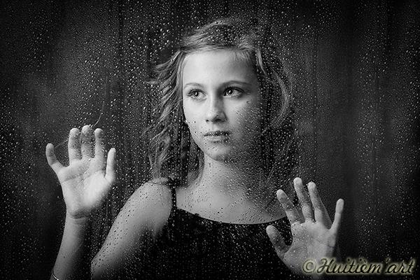 Photographie d'une jeune fille derrière une vitre mouillée par la pluie réalisée par Noelle Gamand Huitièm'art, photographe à Avignon (Vaucluse)