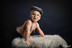 Photographie d'un petit garçon appuyer sur une caisse en bois portant des lunettes des bretelles et une casquette réalisée par noelle gamand portraotiste enfant avignon vaucluse