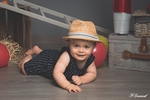 Photographie d'un petit garçon à plat ventre avec un chpeau de paille réalisée par noelle gamand portraitiste enfant avignon vaucluse