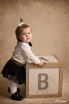 Photographie d'une petite fille debout devant un cube en bois réalisée par Huitièm'art, photographe à Avignon (Vaucluse)