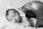 Photographie d'un bébé dormant sous un casque de pompier réalisée par Huitièm'art, photographe à Avignon (Vaucluse)