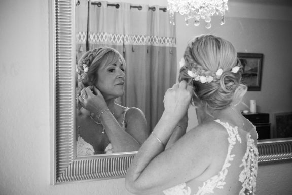Mariée en train de se mettre les boucles d'oreilles devant le miroir